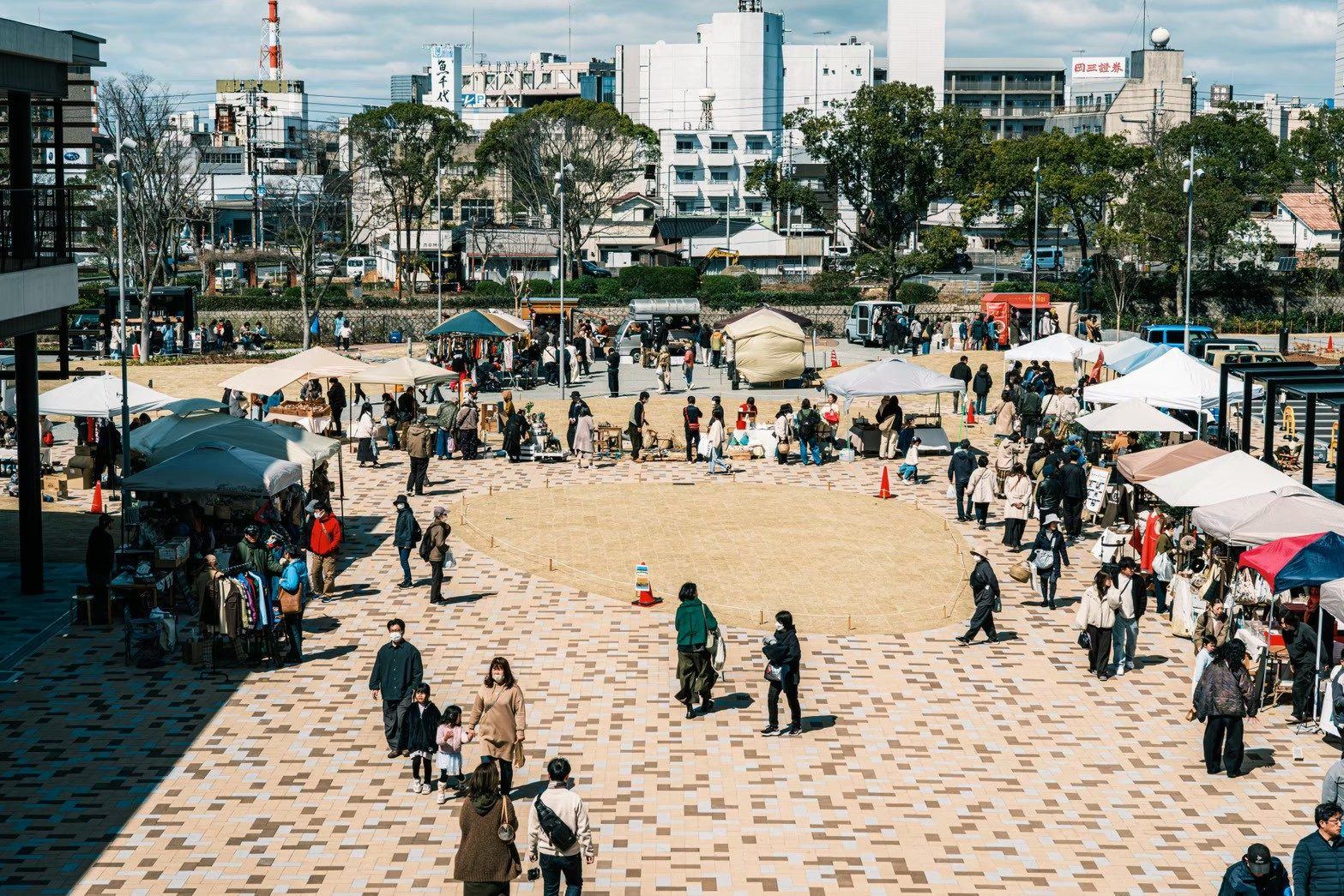 市庭の会場全景。広場に並ぶテントと歩く人たち